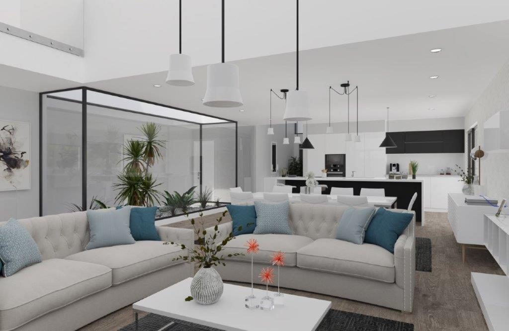 Sala de estar em tons claros aberta sobre cozinha, com sofá cinzento, mesa de centro e plantas